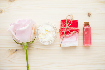 Spa and natural cosmetics concept. Set of sea salt, rose, natural clay ,shea oil, glass bottles and other spa treatment tools on the blue wooden background. Top view. Space for a text. Close up.