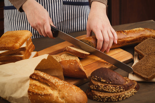 Woman cutting bread on wooden board