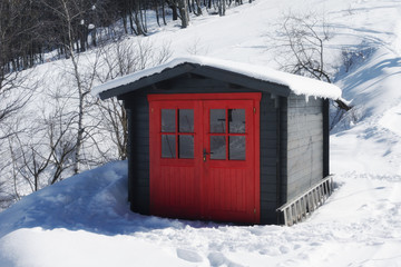 vivid red hut on snow covered mountain in winter
