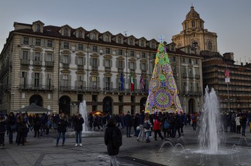 Naklejka premium Turin, Italy, Piedmont, December 8 2017. Piazza Castello adorned with its characteristic Christmas tree, fountains and tourists