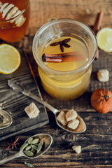 Vitamin tea with lemon and honey, ginger and spices on wooden background . The concept of spring beriberi and colds.