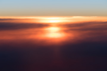 Fototapeta na wymiar Beautiful sunset or sunrise above clouds from airplane perspective