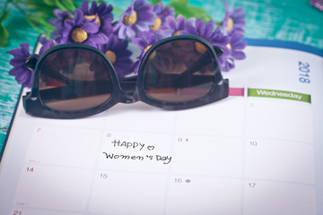 Happy women's day note on calendar book.