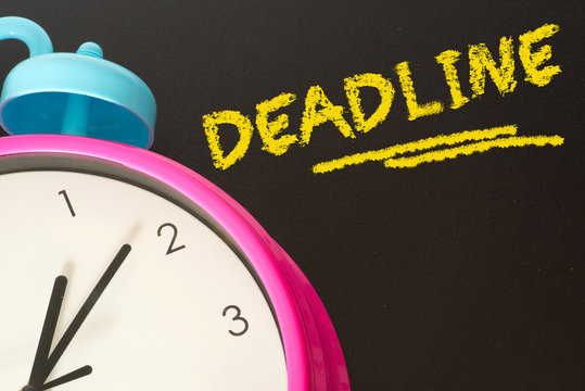 Ein Wecker und Kreidetafel mit dem Wort Deadline