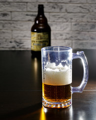 A beer mug and a bottle on the table.
