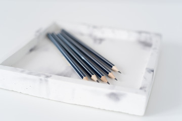 Pencil on marble tray on whie background