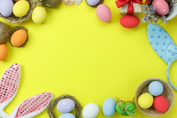 Naklejka na ściany i meble Top view shot of arrangement decoration Happy Easter holiday background concept.Flat lay colorful bunny eggs with accessory ornament on modern beautiful yellow paper at office desk.Design pastel tone.