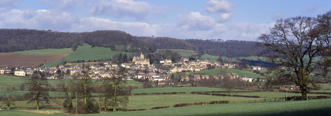 Obraz premium The village of Uley nestled beneath the Cotswold Hills escarpment in spring sunshine, Gloucesteshire, UK.