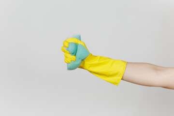 Close up of female hand in yellow gloves holds and squeezes blue large sponge for cleaning and washing dishes isolated on white background. Cleaning supplies concept. Copy space for advertisement