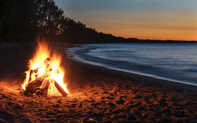 Glowing Bonfire on Beach at Sunset