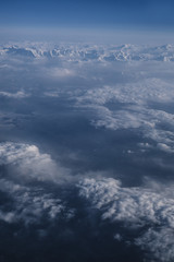 Fototapeta na wymiar Snowy mountains and clouds aerial view