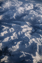Fototapeta premium Snowy mountains and clouds aerial view