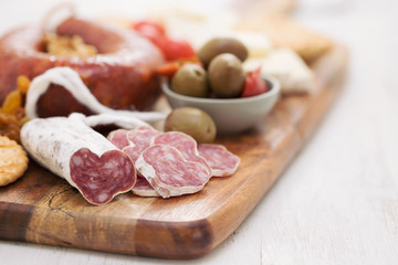 appetizers on wooden board on white wooden background