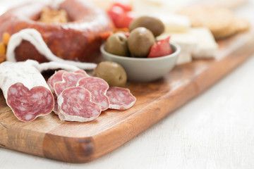 appetizers on wooden board on white wooden background
