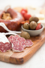 appetizers on wooden board on white wooden background