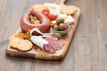 appetizers on wooden board on white wooden background