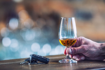 Alcoholism. Cup cognac or brandy hand man the keys to the car and irresponsible driver