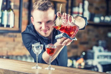 Crédence de cuisine en verre imprimé Cocktail Bartender pouring cocktail alcoholic drink Manhattan.