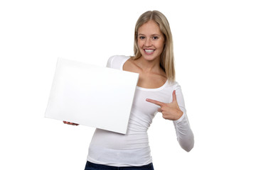 Hübsche blonde Frau lacht und zeigt auf eine leere Tafel in ihrer Hand