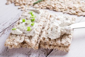 Rye crispbread with soft cheese and fresh herbs. Dietary vegetarian sandwich.Crispy dietary fitness bread.  Food for weight loss