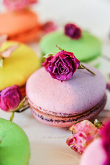 Delicate Fresh Colorful French Macaroons In Pastel Colors With Flowers Roses On A Light Textile Background