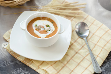Vegetable cream soup with shrimps and croutons in white bowl close up