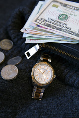 Women's watch, wallet and money cash and coin is on wool. Dollars, yuan, Hong Kong dollars, baht, Lira