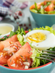 Salad with tomatoes and eggs in a light ceramic plate