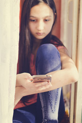 Beautiful teen girl holding a mobile phone. Lifestyle style.