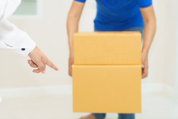 Woman receiving package from delivery man - put it down.