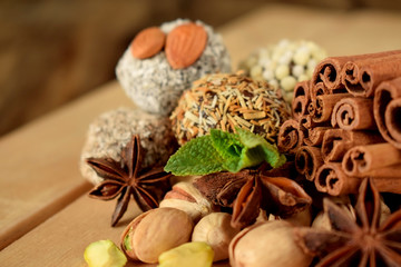 Obraz na płótnie Canvas Sweets with different sprinkles, cinnamon, anise stars, mint and pistachio nuts on wooden boards
