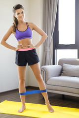 Fototapeta na wymiar Fitness workout at home with rubber resistance band