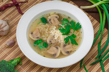 Mushrooms soup with greens, garlic and parmesan cheese. Rustic style. Wooden rustic background. Top view