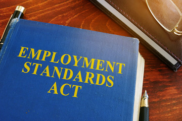 Employment standards act and glasses on a desk.