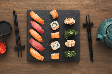 Top view set of sushi maki and rolls near teapot © Prostock-studio