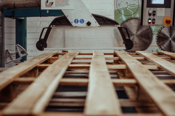 A wooden studio with a big cutting equipment cutting a big woods