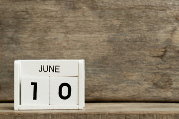 White block calendar present date 10 and month June on wood background