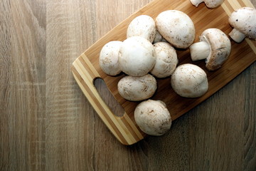 Fresh organic champignons on wooden background