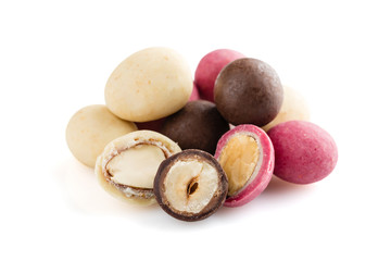 Heap of sugared almonds and hazelnuts dragees in chocolate isolated on white background