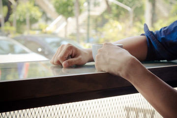 Obraz premium man holding hot latte coffee cup for break time after meeting; relax concept with copy space