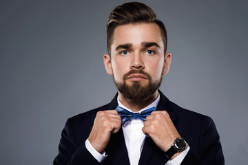 Stylish handsome man wearing a classic suit with bow-tie