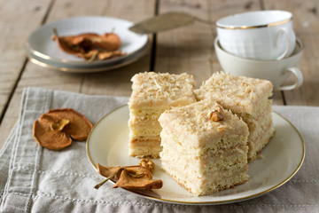 Pieces of apple cake and dried apples on a wooden table. Rustic style.