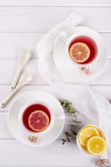 Two cups of red fruit and herbal tea with lemon slice, top view