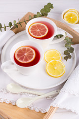 Two cups of red fruit and herbal tea with lemon slice, top view
