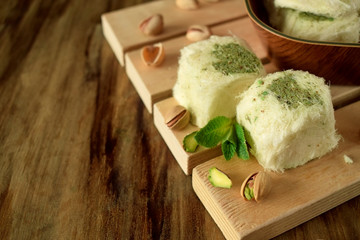 Turkish dessert. Cotton candy with pistachio on wooden boards surrounded by nuts