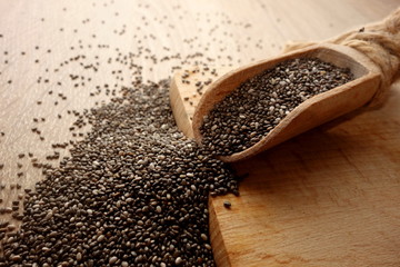 Chia seeds in scoop on rustic wooden background