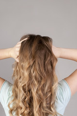 Fototapeta premium A young girl from the back with a strong headache. Convulsive spasm and headaches concept.