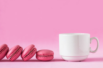 White cup and pink macaroons on pink