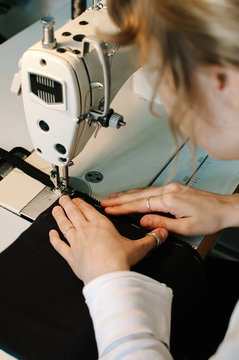 Young fashion designer working at sewing machine