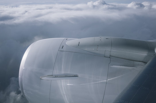 View from outside commercial jet window of engine, wing and sky